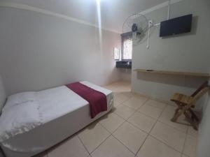 a bedroom with a bed and a television and a chair at HOTEL ASSIS in Assis