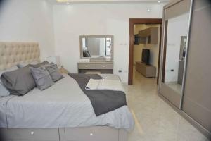 a bedroom with a large bed and a mirror at Amazing one Bedroom Apartment in Amman Elwebdah 4 in Amman