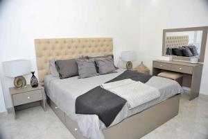 ein Schlafzimmer mit einem großen Bett und zwei Nachttischen in der Unterkunft Amazing one Bedroom Apartment in Amman Elwebdah 7 in Amman