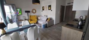 - un salon avec un canapé et un fauteuil jaune dans l'établissement Ustronie Morskie Sianożęty 5 mórz Golden Beach, à Sianożęty