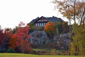 a house on top of a hill with trees at Muskoka Bay Resort in Gravenhurst