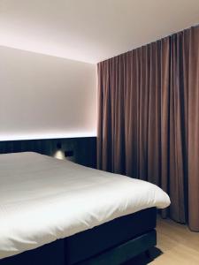 ein Schlafzimmer mit einem Bett und einem Vorhang in der Unterkunft Suites Le Porte-Bonheur in Brügge + 31 Fotos
