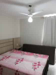 a bedroom with a bed with pink flowers on it at CALDAS NOVAS - GO - Apartamento Parque das Aguas Quentes bloco 1 - em frente Clube Privê in Caldas Novas