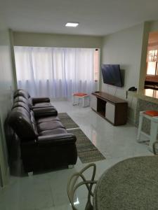 a living room with a leather couch and a television at CALDAS NOVAS - GO - Apartamento Parque das Aguas Quentes bloco 1 - em frente Clube Privê in Caldas Novas