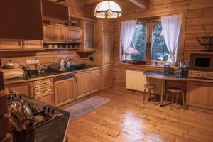 a kitchen with wooden cabinets and a table with chairs at Krasna Chata Maniowy in Maniowy