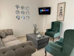 a living room with a couch and two chairs and a tv at CASA PONIENTE in Hermosillo