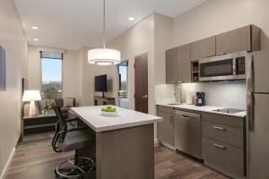 a kitchen with a refrigerator, microwave, sink, and dishwasher at Hyatt House Atlanta Perimeter Center in Atlanta
