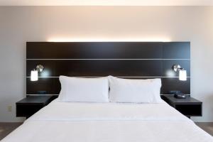 Vadnais Heights的住宿－Holiday Inn Express Hotel & Suites-St. Paul, an IHG Hotel，一间卧室配有一张带2个床头柜的大型白色床