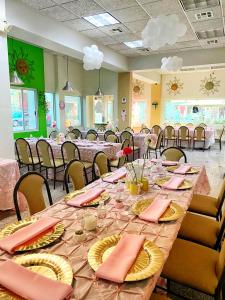 提華納的住宿－REAL INN de Tijuana，用餐室配有桌椅和粉红色餐巾