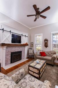 un salon avec une cheminée et un ventilateur de plafond dans l'établissement Cottage, à Green Lake