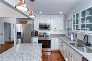 une cuisine avec des armoires blanches et un réfrigérateur en acier inoxydable dans l'établissement Cottage, à Green Lake