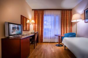 a bedroom with a television and a bed at Park Inn by Radisson Poliarnie Zori in Murmansk