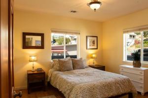 a bedroom with a bed and two windows at 90 San Luis Street Unit C in Avila Beach