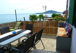 eine Terrasse mit einem Tisch, Stühlen und Meerblick in der Unterkunft Holiday home Villa Jadran - 10 m from beach in Preko