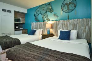 2 Betten in einem Zimmer mit blauen Wänden in der Unterkunft Skwachàys Lodge in Vancouver