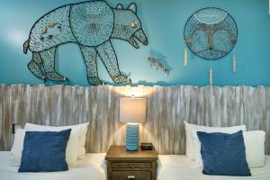 a bedroom with a bed with a elephant mural on the wall at Skwachàys Lodge in Vancouver