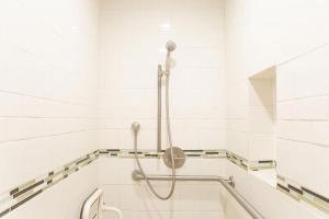 a shower in a bathroom with white tiles at 90 San Luis Street Unit B in Avila Beach +8 photos