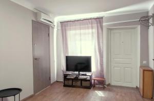 ein Wohnzimmer mit einem TV und einem Fenster in der Unterkunft квартира в центре in Odessa