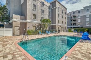 a swimming pool with blue chairs and a building at Holiday Inn Express Hotel & Suites Clearwater US 19 North, an IHG Hotel in Clearwater