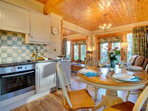 a kitchen and dining room with a wooden ceiling at Apple Tree Lodge in Swarland