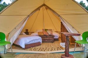 a tent with a bed and a table and chairs at Glampwild Zaquencipa in Villa de Leyva