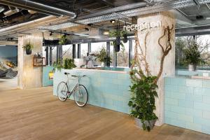a bike parked next to a counter with plants at 25hours Hotel Bikini Berlin in Berlin