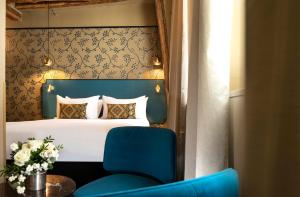 a bedroom with a bed and a blue chair at Hôtel Des Deux-Iles - Notre-Dame in Paris