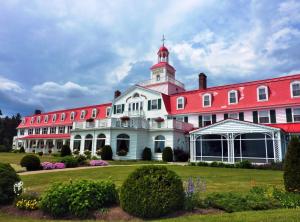 a large red and white building with a clock on the front of it at Hotel Tadoussac in Tadoussac