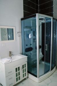 a bathroom with a glass shower and a sink at Ocean Park Hotel,Lekki phase 1 in Lekki