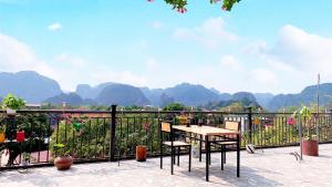 d'une table et de chaises sur un balcon avec des montagnes en arrière-plan. dans l'établissement Hang Múa Lucky House, à Ninh Binh