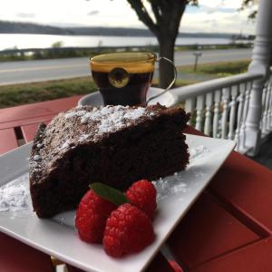 a piece of chocolate cake on a plate with two raspberries at Toba's Bed & Breakfast in East LaHave