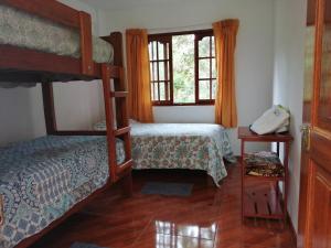 1 dormitorio con 2 literas y ventana en Illariy Tampu Ecoalbergue Oxapampa, en Oxapampa