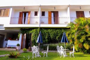 a house with chairs and umbrellas in front of it at Pousada do Lago in Petrópolis