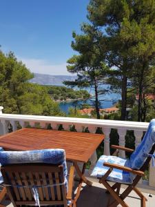 een tafel en stoelen op een balkon met uitzicht op het water bij Apartments and rooms Makaj - 80 m from the beach in Basina