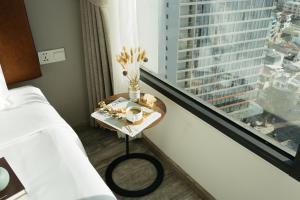 a room with a bed and a table next to a window at Em Oi Boutique Hotel in Nha Trang
