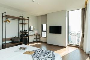 a bedroom with a bed and a flat screen tv at Em Oi Boutique Hotel in Nha Trang