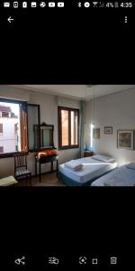 a bedroom with two beds and a window at Cà Widmann in Venice