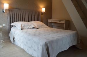 sypialnia z łóżkiem z białą pościelą i poduszkami w obiekcie Hôtel Restaurant Aux Genêts d'Or w mieście Mandailles