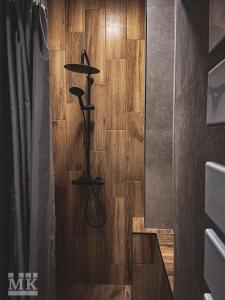 a bathroom with a shower with a wooden floor at Magiczne Mieszkanko in Piła