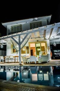 a house with a pool of water in front of it at Riverland beach villa in Protaras