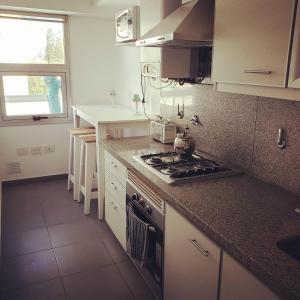 una cucina con fornelli e piano di lavoro di Luz de Madryn a Puerto Madryn