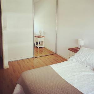 una camera con un grande specchio e un letto di Luz de Madryn a Puerto Madryn Altre 10 foto