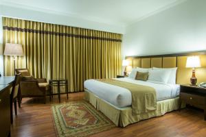 a hotel room with a large bed and a desk at The Sera Courtyard in Leh