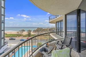 a balcony with two chairs and a view of the beach at Boulevard North Holiday Apartments in Gold Coast