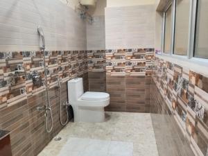 un baño con inodoro y ducha en URBAN COTTAGE, en Guwahati 80 fotos más