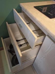 a kitchen counter with a drawers with knives at Student Park Hotel in Yogyakarta