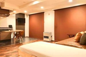 a bedroom with a bed and a kitchen and a table at MolinHotels205 -Sapporo Onsen Story- 1Room S-Bed6 6persons in Jozankei