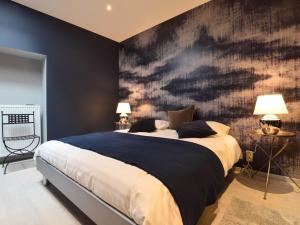 een slaapkamer met een groot bed met een zwarte muur bij Splendid ground floor apartment with garden in the very center of Spa in Spa