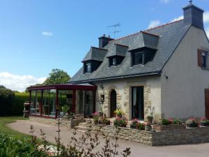 Pédernec的住宿－Modern house in Brittany near the Pink Granite Coast，前面有温室的房子