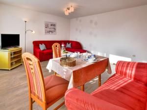 ein Wohnzimmer mit einem Tisch und einem roten Sofa in der Unterkunft Modern Apartment in Klutz with Sea Nearby in Klütz